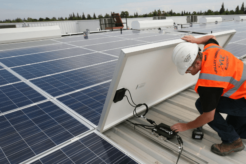Aurinkosähköjärjestelmän pitkäikäisyys, asentaja asentaa aurinkopaneeleja